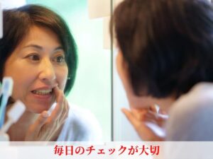 鏡で歯をチェックする女性