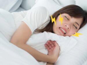 睡眠中に歯ぎしりをする女性